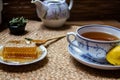 Morning tea time, cup of natural tea, teapot, organic honey, fresh green tea leaves and organic fruits