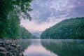 Morning silence, mystical foggy summer landscape, mountain river surrounded by green forest with reflection in the water Royalty Free Stock Photo