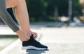 Morning starts with run. Guy ties laces on his sneakers on street Royalty Free Stock Photo