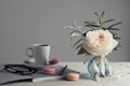 Morning still life with vintage rose in a vase, coffee and macarons on a light table. Beautiful and cozy breakfast.