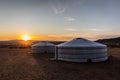 The morning sun bathes two yurts in central Mongolia in a morning glow.