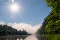 Morning sun and fog over the river in the mountains. Nature for the design of photo wallpaper or for desktop to computer. Royalty Free Stock Photo