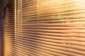 Morning sunlight at sunrise shining through the slats of horizontal venetian blinds Royalty Free Stock Photo