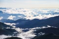 Morning sunny mountains landscape with thick fog, blue sky and clouds. Spring scenery.