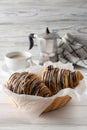 Morning table with coffee, freshly baked croissants with chocolate