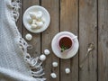 Morning tea. Ceramic decorative vase. Meringue cookies, composition on a wooden unpainted table, a part of a white tablecloth