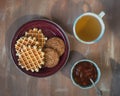 Morning tea with cookies, waffles and apple jam on the brown table Royalty Free Stock Photo