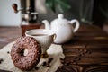 Morning tea with sweet doughnut. A white vintage cup of coffee next to a teapot and freshly ground coffee in an antique Royalty Free Stock Photo