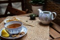 Morning tea time, cup of natural tea, teapot, organic honey, fresh green tea leaves and organic fruits