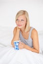 Morning, tea and woman relax in bed and thinking in home planning ideas for future. Healthy, person and calm girl with Royalty Free Stock Photo