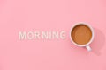 MORNING text with a cup of coffee with shadow on pink background Royalty Free Stock Photo