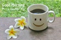 Morning text greeting - Good Morning. Have a beautiful Day. A cup of coffee with happy smiling sign emoticon on it and flower.