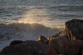 morning tide clashes with rocks energetically, sunrise storm hitting rugged shoreline vigorously Royalty Free Stock Photo