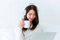 Happy young asian woman relax on comfortable couch at home texting messaging on smartphone Royalty Free Stock Photo