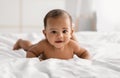 Cute adorable little African American kid lying on comfortable bed Royalty Free Stock Photo