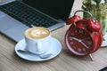 Morning time with warm light. alarm clock, laptop, and coffee cup on working desk. Royalty Free Stock Photo