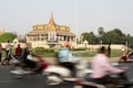 Morning traffic speeds past the Royal Palace in central Phnom Penh