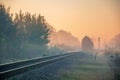 Morning train passing in the autumn haze at sunrise light Royalty Free Stock Photo