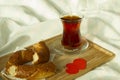 Morning turkish tea in traditional glass with bagel on the tray