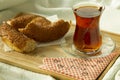 Morning turkish tea in traditional glass with bagel on the tray, breakfast in bed