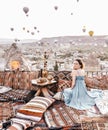 Morning view in Cappadocia. Terrace view in Goreme woman with hot air balloons and carpets Royalty Free Stock Photo