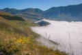 Morning view of Castelluccio di Norcia village absorbed in the fog, Umbria, Italy