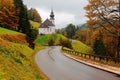 Morning view of Church Maria Gern on the autumn hillside with a curving road passing by Royalty Free Stock Photo