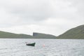 Morning view on lonely boat on cloudy Sorvagsvatn lake