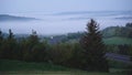 Morning view from the mountain to the mountains, forest and highway in the fog.