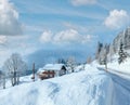 Morning winter misty rural view with alpine road and house on the roadside Royalty Free Stock Photo