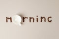 Morning word shaped with coffee beans and empty whote cup on gray background, minimal concept