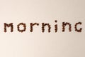 Morning word shaped with coffee beans on gray background, minimal concept