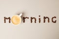 Morning word shaped with coffee beans and white cup wth fresh hot espresso drink on gray background, minimal concept