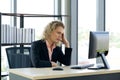 Morning work atmosphere In a modern office. Ukrainian employee hold the head with one hand at her desk. After receiving the