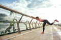 Morning workout. Disabled athletic woman with prosthetic leg in sportswear doing sport exercises while standing on the Royalty Free Stock Photo