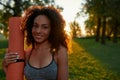 Morning workout. Portrait of a young happy mixed race woman holding yoga mat and smiling at camera while standing in the Royalty Free Stock Photo