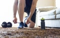 Morning workout routine at home gym. Fitness motivation concept. Man in sneakers tying shoelaces in sunlight. The athlete begins Royalty Free Stock Photo