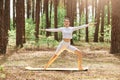 Morning yoga outdoors in park, young beautiful woman instructor wearing white stylish sportswear standing on mat surrounding with Royalty Free Stock Photo