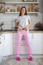 Morning young woman in pajama in modern house kitchen, happy and smiling