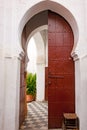 Oriental door. Old moroccan red painted wooden door with oriental frame leading to patio and garden..