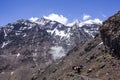 Moroccan Berber men walk with their mules on the roads of the great atlas of Morocco. Great mountains and a blue sky are in the