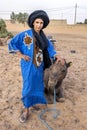 A Moroccan boy stands with a camel at Merzouga, which lies on the edge of Erg Chebbi in Morocco.