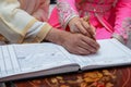 A Moroccan bride and groom sign their marriage book.