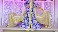 A Moroccan bride sits on the wedding chair in the traditional Moroccan dress. The caftan