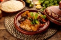 Moroccan Chicken and Vegetables Tangine with Couscous and bread served in a dish isolated on wooden background side view Royalty Free Stock Photo