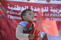 A Moroccan child from the Moroccan desert holds the Moroccan flag