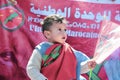 A Moroccan child from the Moroccan desert holds the Moroccan flag
