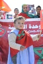 A Moroccan child from the Moroccan desert holds the Moroccan flag