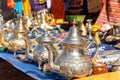 Moroccan craft souvenirs on street market. Teapots, jewelry, tagines, trinkets