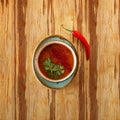 Moroccan food, tomatoe soup dish decorated with parsley, on a plate with red hot chili pepper, on a wooden table Royalty Free Stock Photo